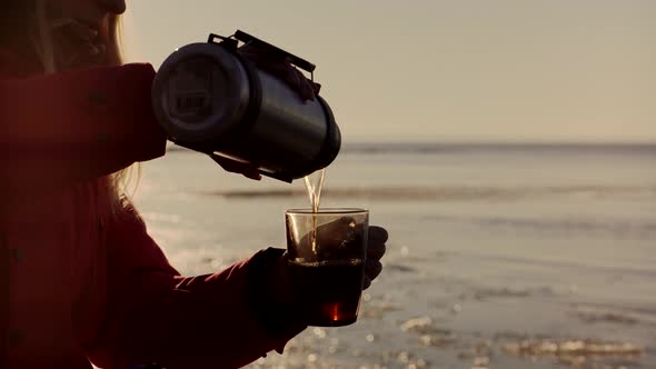 Traveler Enjoying Hot Tea In Mug On Forest Adventure. Refreshment From Thermos. Hot Tea Into Cup.