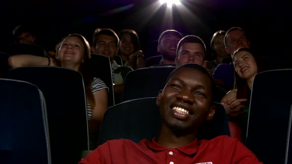 Happy Multiethnic Young Men Watching Movie in the Theatre