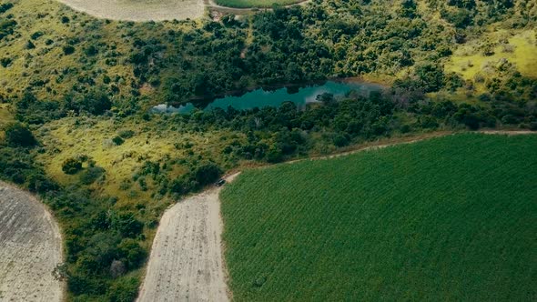 Incredible high aerial drone shot flying over rural farm fields in the countryside on a beautiful su