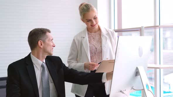 Two Business People Talk Project Strategy at Office