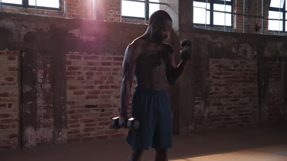 Sport man doing arm exercise with weight at gym portrait