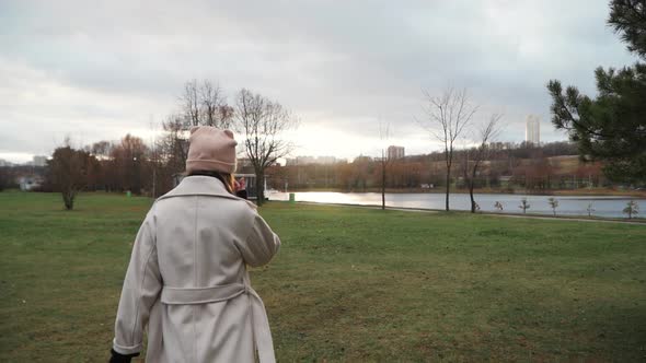 Girl in a Coat Walks Along