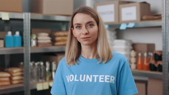 Young Female Volunteer Posing at Food Bank Warehouse