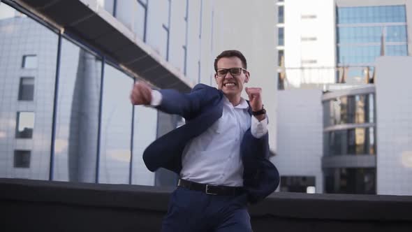 Front View of Young Businessman Looking Around to Sure Noone See Him and Starts to Express His