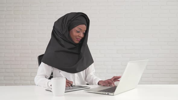 Woman Working on Digital Tablet and Laptop