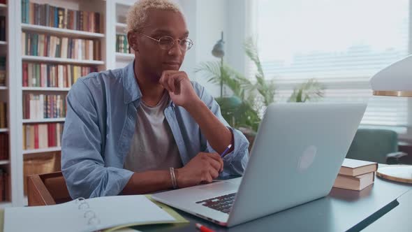 Portrait of Attentive Businessman with Glasses Sitting at Office Desk at Work