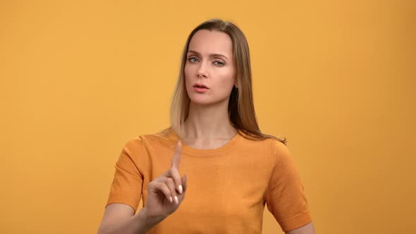 Portrait Frowning Woman Showing No Not Dont Gesture Shaking Forefinger Posing Isolated on Orange