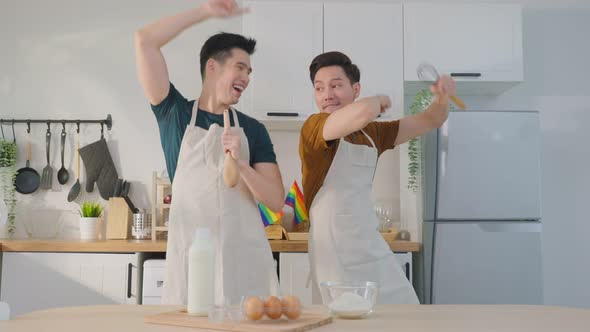 Asian happy handsome man gay couple sing and dance together in kitchen.