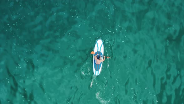 Drone Footage of a Tourist Paddling Within the Ocean