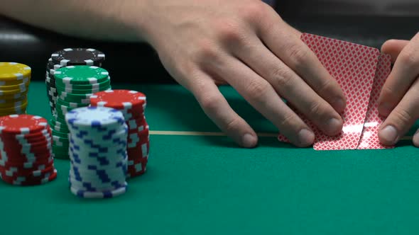 People Playing Poker, Man Looking at His Cards and Pushing Chips, All-In