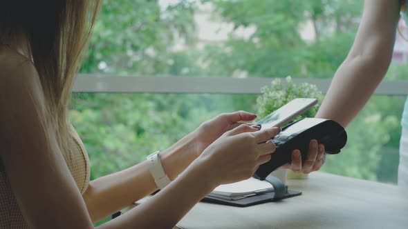 Young Asian Woman using a Mobile Phone Smart payment in the Coffeeshop 03