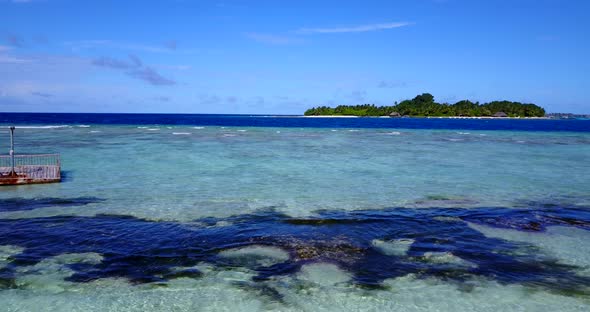 Tropical above island view of a sunshine white sandy paradise beach and aqua blue ocean background 