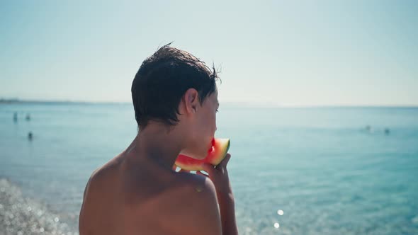 Boy Eating Watermelon on the Beach Summertime