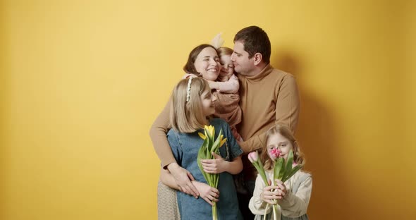 Mother Father and Kids Hugs Having Fun Time and Posing on Yellow Background