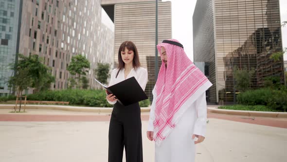 Businesspeople Discussing Papers During Meeting on Street