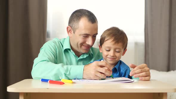 Dad and Son Spend Time Painting with Colored Felt Pen. The Concept of a Happy Family