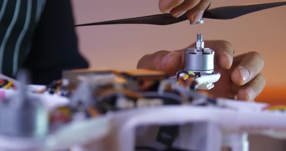 Male Hands Mount the Propeller on the Disassembled Drone