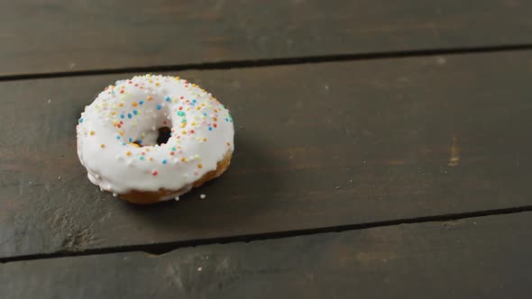 Video of donut with icing on wooden background