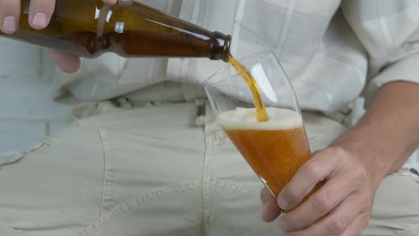 A man pours beer into a glass.