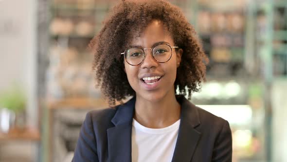 Cheerful African Businesswoman Waving at the Camera 