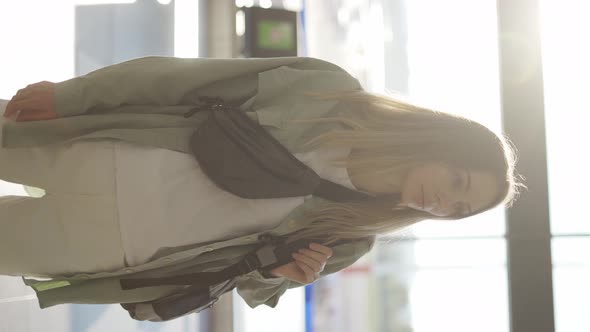 Portrait of a Stylish Young Blonde Girl Traveller Stands in Airport Terminal