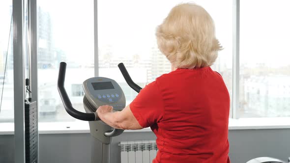 Backview on Retired Woman in Gym Doing Cardio Exercise