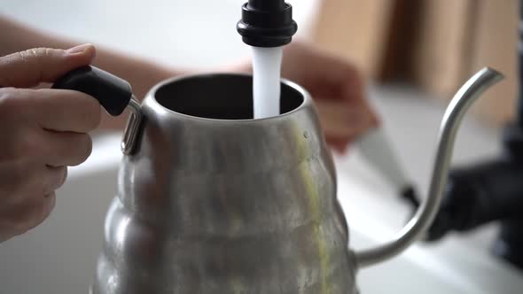 Woman filling coffee kettle with water