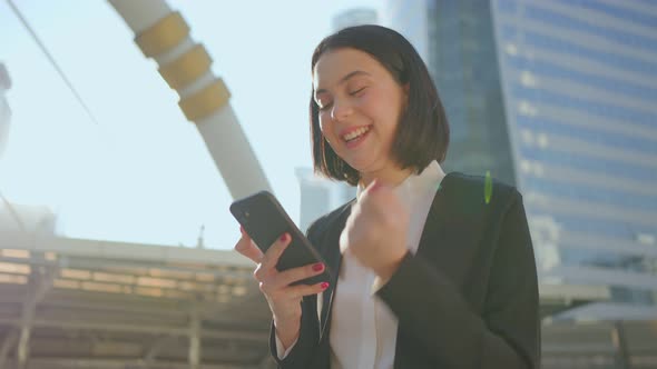 Asian unemployed woman feeling happy after she looking at smartphone know the result of interview.