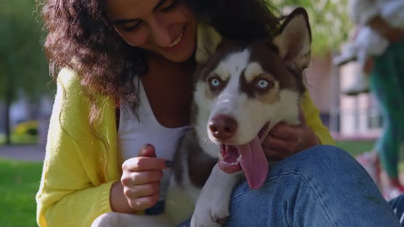 Purebred Husky Dog in Hands of Female Owner in Park