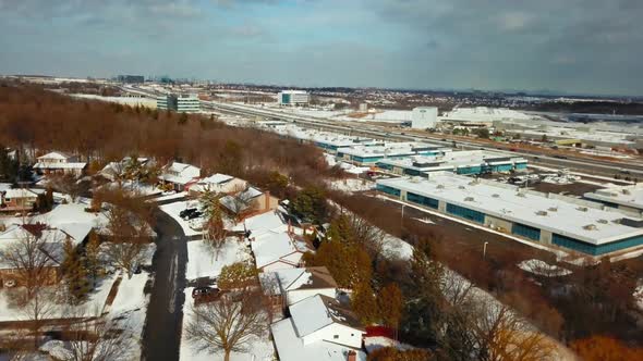 Winter aerial flying over a suburban neighbourhood and a busy highway.