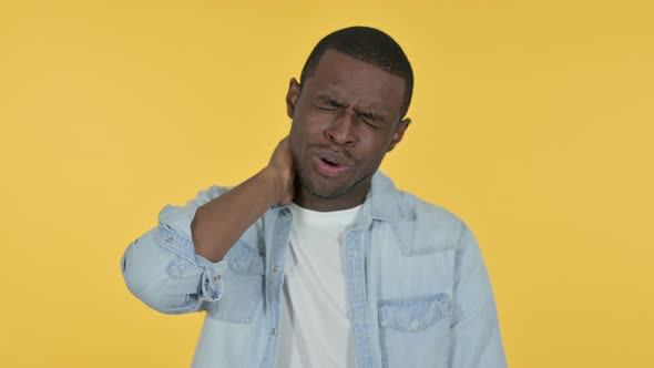 Young African Man Having Neck Pain, Yellow Background 