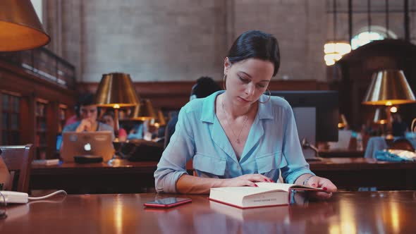 Young girl reading a book in the library