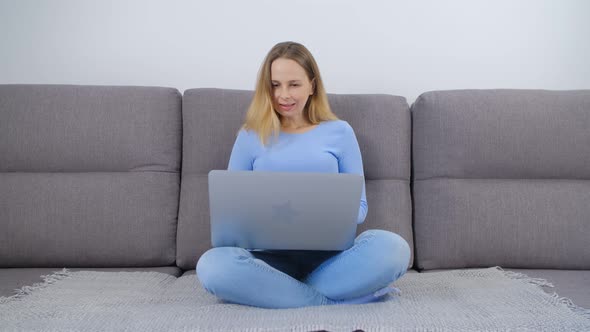 Freelance writer typing on laptop computer at home on couch in 4k video