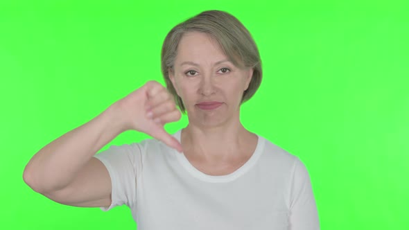 Thumbs Down By Old Woman on Green Background