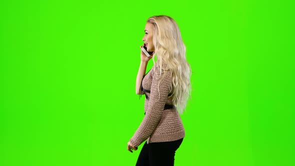 Blond Girl Talking on the Phone. Green Screen. Side View