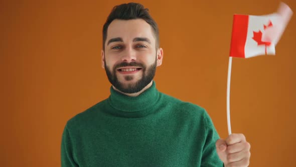 Slow Motion Portrait of Bearded Young Student with Canadian Flag Smiling