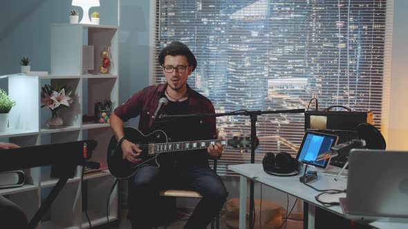 Musician Trying Sound Recording Equipment in Home Studio in the Eve