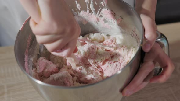 Pastry Chef Mixing Dough for Pink Macarons Shells in a Steel Bowl, Close Up