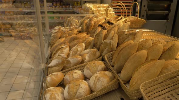 Pan left shot of breads on display in supermarket bakery