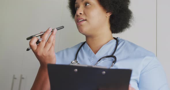 Video of focused plus size african american female doctor using smartphone