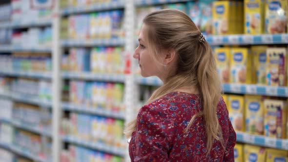 Attractive Young Woman Choosing Products in Supermarket Marketplace.