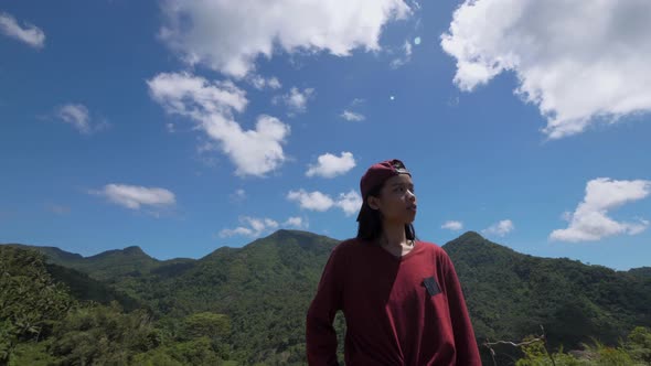 Asian Young Woman Stands On A Mountain and Looks Around in Asia Travels Through the Jungle Among