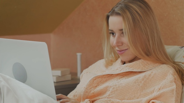 Full length side view of female patient using laptop on