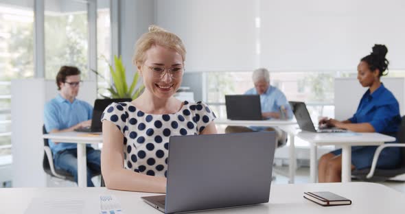 Portrait of Smiling Pretty Young Business Woman Sitting on Workplace