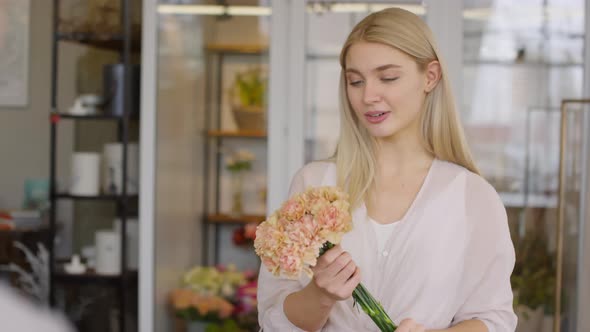 Beautiful Woman Choosing Bouquet at Flower Shop