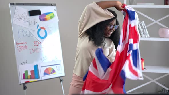 Young Happy African American Woman Wrapping in British Flag Looking at Camera Smiling