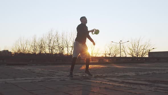 Young and fit man having evening workout outdoor. Urban sunset.