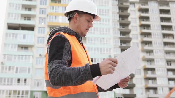 The foreman at the construction site of a high-rise building will check the drawings.