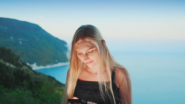Woman Using Smartphone with Ocean in the Background