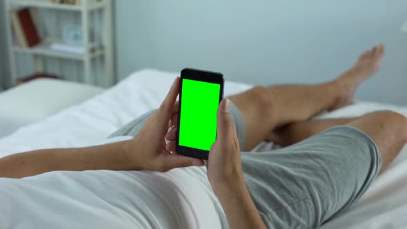 Man Holding Smartphone With Green Screen, Downloading New Software for Gadget